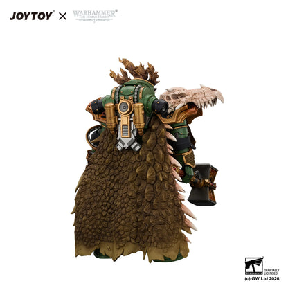 Warhammer 40k JOYTOY x Officially Licensed Design by Games figure of a heavily armored Space Marine from behind, wearing green and gold armor with a large brown scaly cloak and holding a skull weapon, on a white background.