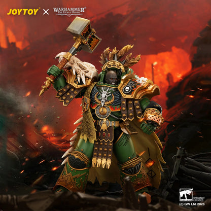 A detailed collectible figure of a Warhammer 40k Space Marine warrior with a skull helmet, green and gold armor, and a large hammer, posed in a fiery, battle-scene background. Visible logos include JOYTOY, Warhammer 40k, and Special Effects Figures.