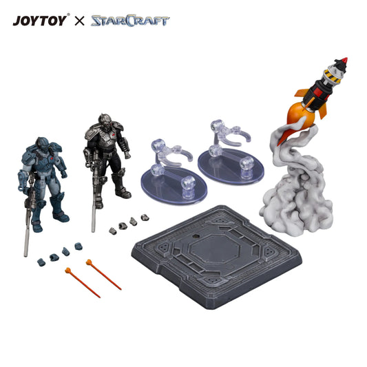 A StarCraft x JoyToy tabletop gaming accessory set on a white background, featuring two action figures, a rocket ship figure, two clear stands, small accessories, and a dark gray baseplate.
