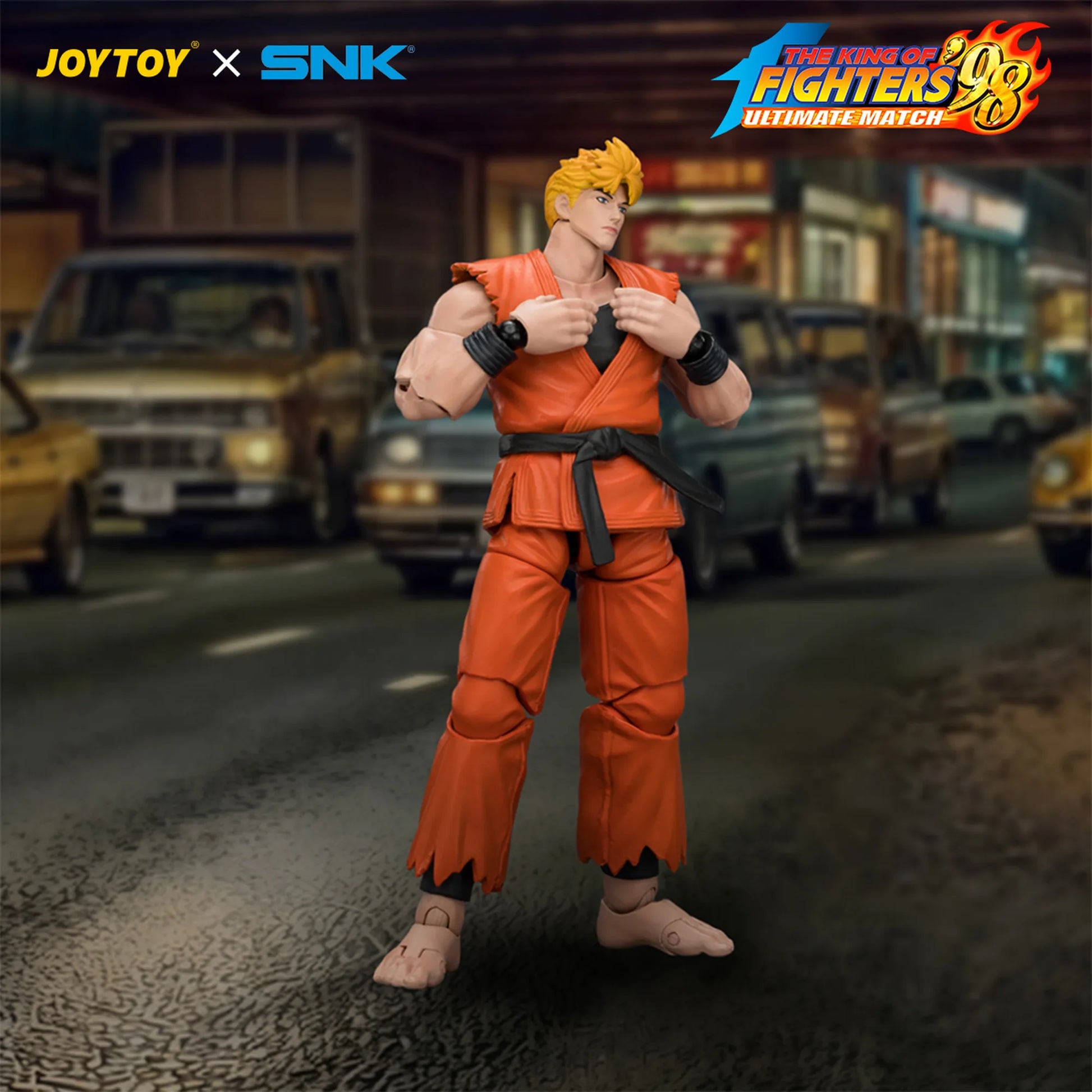 Action figure in orange outfit with 'JOYTOY' and 'SNK' branding on a blurred street background.