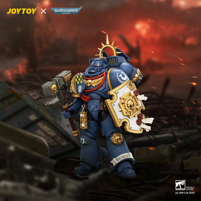 Toy figure of a warrior in ornate armor with a shield and axe, set against a fiery battlefield background. Brand 'JOYTOY' and 'Warhammer' visible.