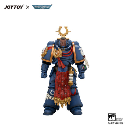 A detailed action figure of a Warhammer 40k Space Marine Imperial Legion Veteran, featuring blue armor with gold accents, a red sash, and a gold crescent sun helmet, shown on a white background with JOYTOY and Warhammer 40k branding.