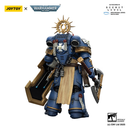 Toy figure of a warrior in blue armor with gold accents, featuring Joytoy and Warhammer branding.